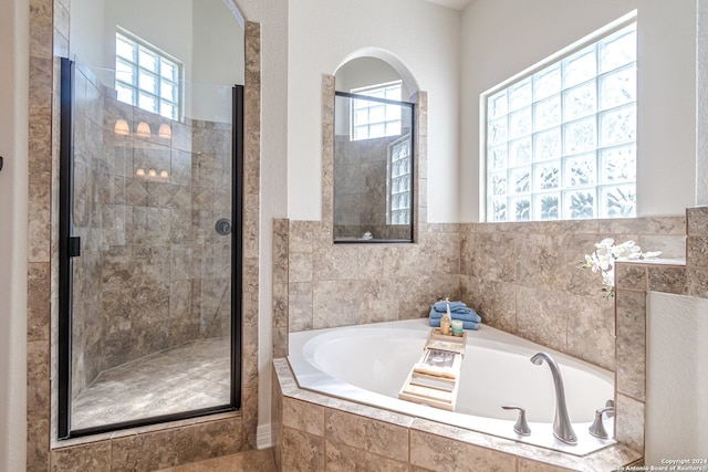 bathroom with separate shower and tub and a wealth of natural light