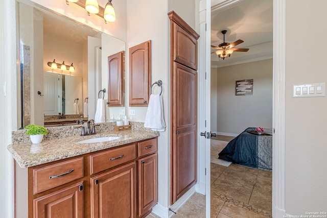 bathroom with tile patterned flooring, ornamental molding, vanity, and ceiling fan