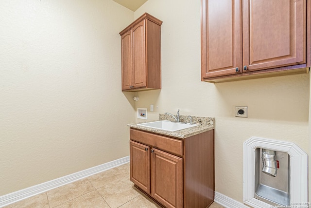 laundry area with light tile patterned flooring, washer hookup, cabinets, hookup for an electric dryer, and sink