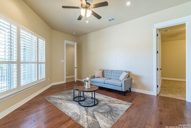 living room featuring ceiling fan and dark wood-type flooring