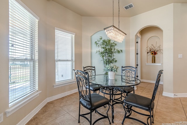 tiled dining area featuring a chandelier and a wealth of natural light