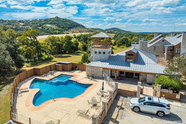 view of swimming pool featuring a patio area, a mountain view, and an outdoor hot tub