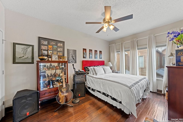 bedroom with a textured ceiling, ceiling fan, and dark hardwood / wood-style flooring