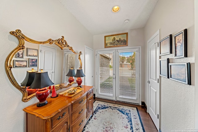 doorway with dark hardwood / wood-style floors and a textured ceiling