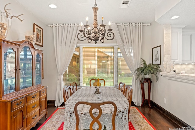 dining area with a notable chandelier, dark hardwood / wood-style floors, and a textured ceiling