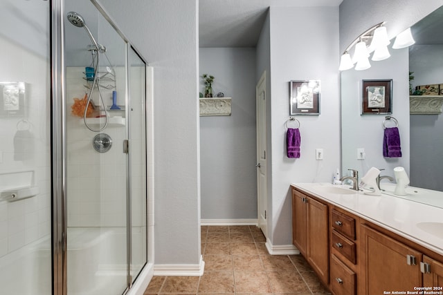 bathroom with vanity, a shower with door, and tile patterned floors