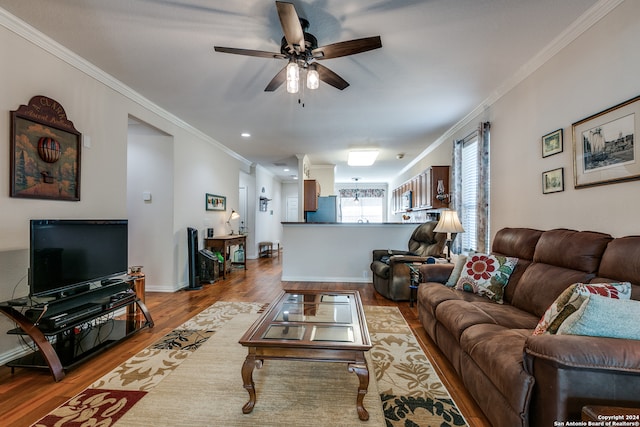 living room with light hardwood / wood-style floors, crown molding, and ceiling fan