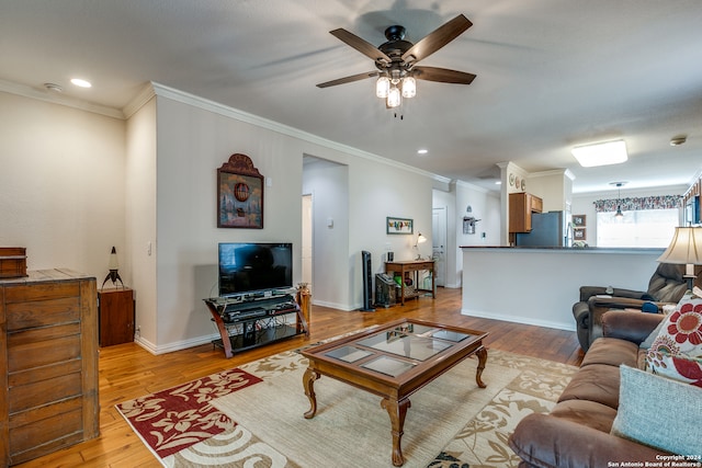 living room with ornamental molding, light wood-type flooring, and ceiling fan