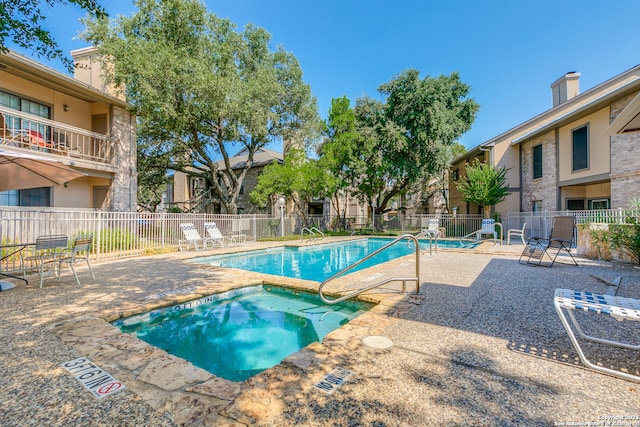 view of pool with a hot tub and a patio area