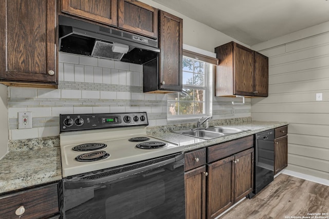 kitchen with dark brown cabinetry, ventilation hood, light hardwood / wood-style floors, black dishwasher, and white range with electric cooktop