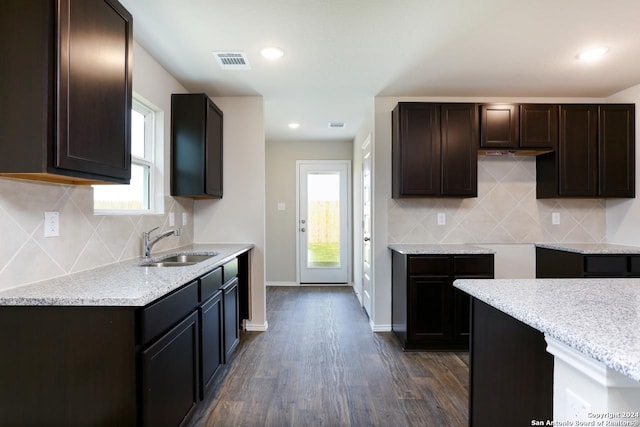 kitchen featuring decorative backsplash, dark brown cabinetry, dark hardwood / wood-style flooring, and sink