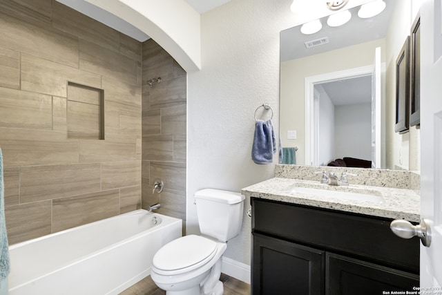 full bathroom with toilet, vanity, and tiled shower / bath combo