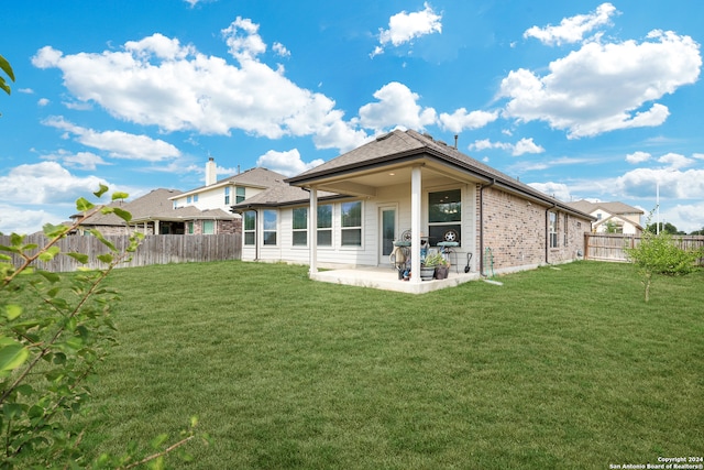 back of property featuring a yard and a patio