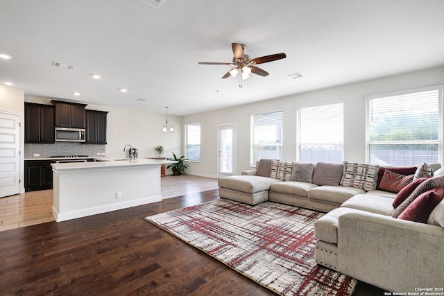 living room featuring ceiling fan, sink, and dark hardwood / wood-style flooring