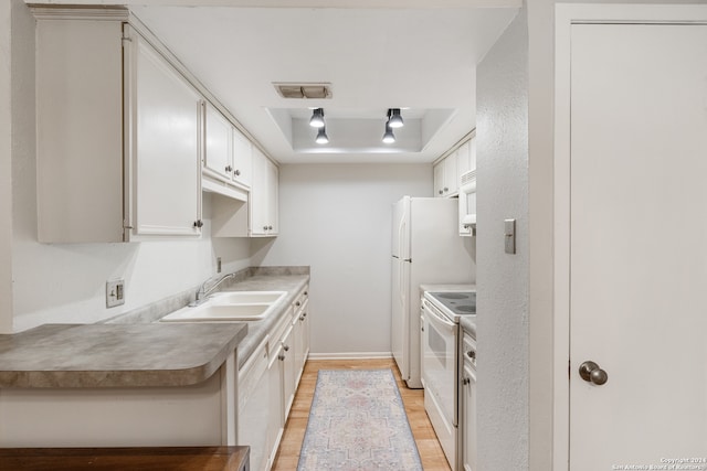 kitchen with sink, light hardwood / wood-style floors, white cabinets, a tray ceiling, and white electric range