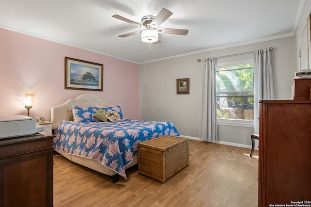 bedroom with ceiling fan, a textured ceiling, light hardwood / wood-style floors, and crown molding