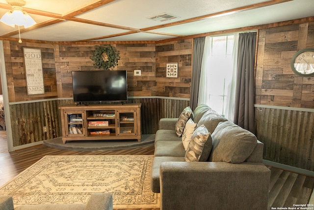 living room with ceiling fan, wood walls, and dark hardwood / wood-style floors