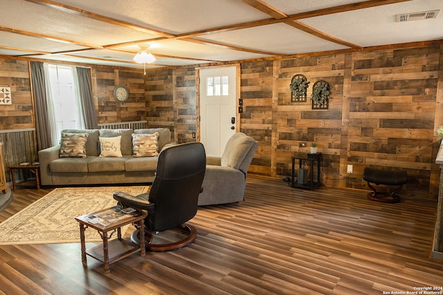 living room with a textured ceiling, wood walls, and dark wood-type flooring