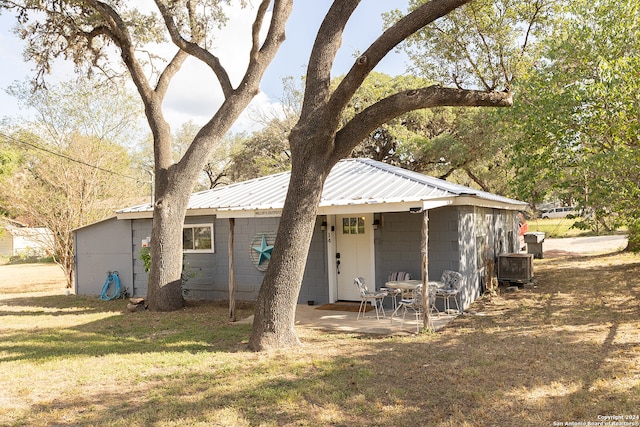 rear view of property with a lawn and a patio area