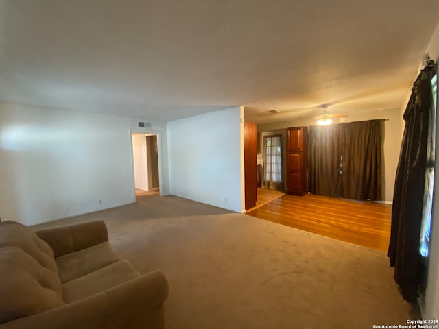 unfurnished living room with light wood-type flooring and ceiling fan