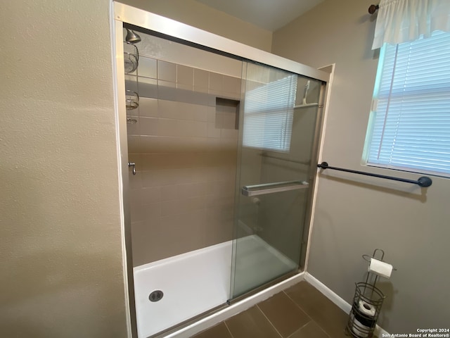 bathroom with tile patterned flooring and a shower with door