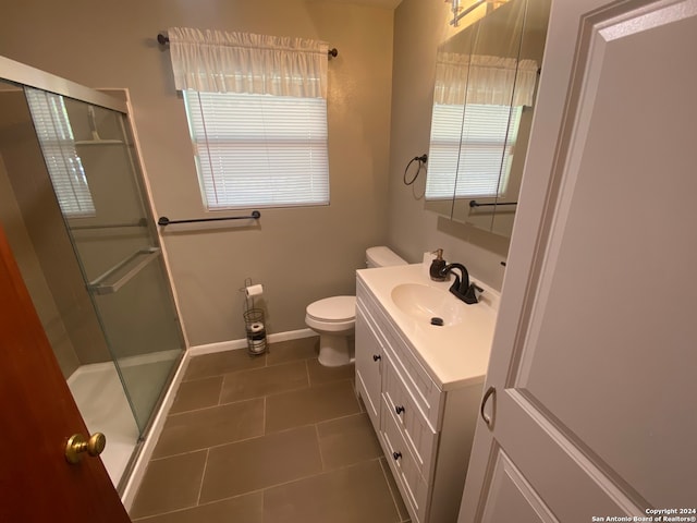 bathroom with an enclosed shower, tile patterned floors, vanity, and toilet