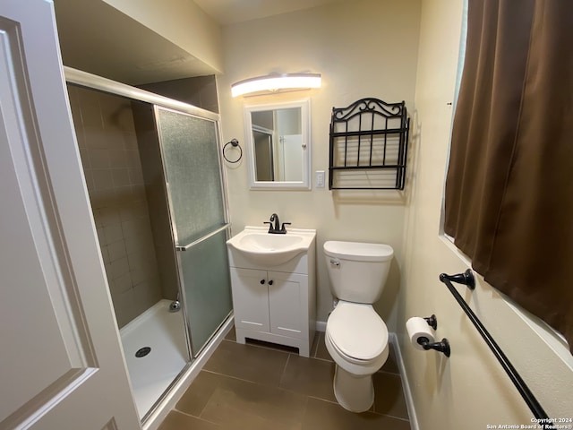 bathroom with vanity, tile patterned flooring, toilet, and an enclosed shower