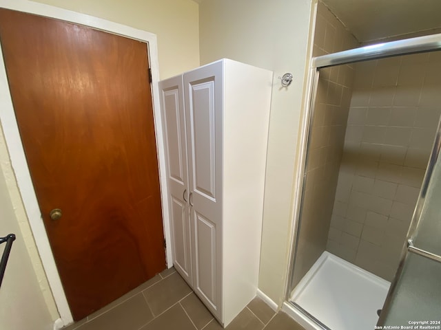 bathroom featuring a shower with shower door and tile patterned flooring