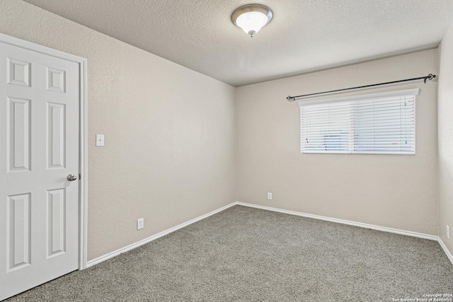 carpeted empty room featuring a textured ceiling