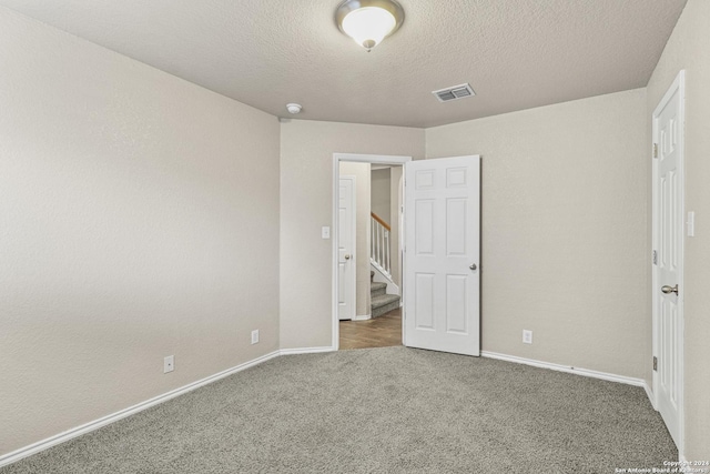 unfurnished bedroom with carpet and a textured ceiling