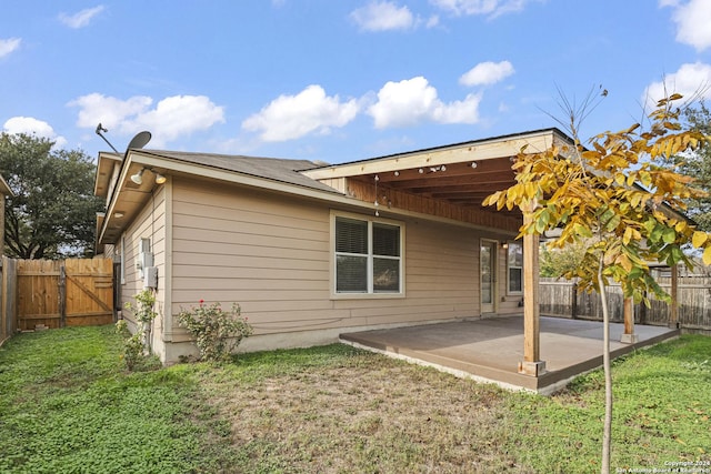 rear view of house featuring a yard and a patio