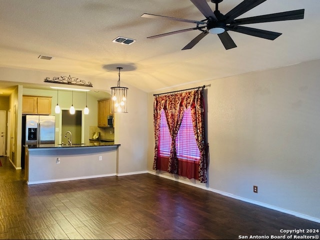 unfurnished living room featuring ceiling fan with notable chandelier, sink, dark wood-type flooring, and vaulted ceiling