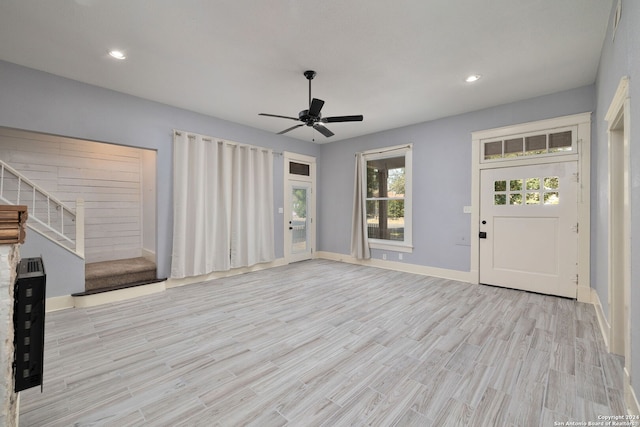 entrance foyer with ceiling fan, a healthy amount of sunlight, and light wood-type flooring