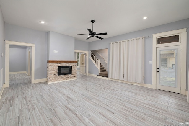 unfurnished living room with ceiling fan, light hardwood / wood-style floors, and a fireplace