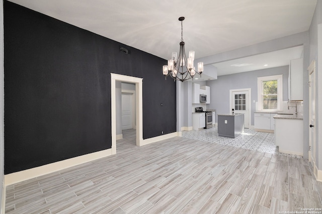 722 E Drexel Ave, San Antonio, TX 78210 - kitchen with stainless steel appliances, a chandelier, light wood finished floors, white cabinetry, and a center island