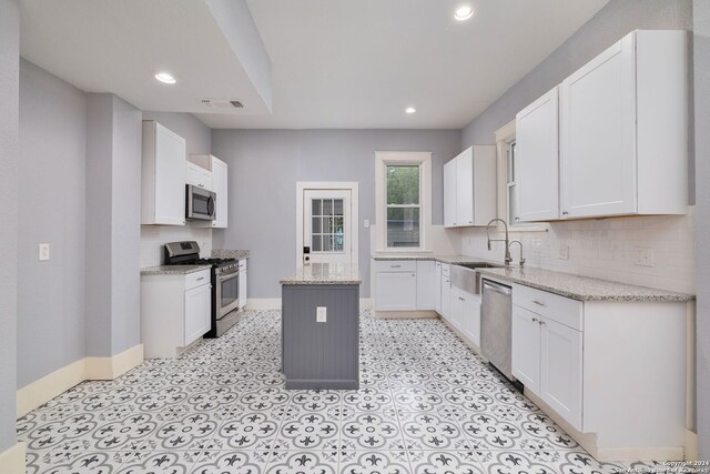 722 E Drexel Ave, San Antonio, TX 78210 - kitchen with appliances with stainless steel finishes, a kitchen island, baseboards, tasteful backsplash, and recessed lighting