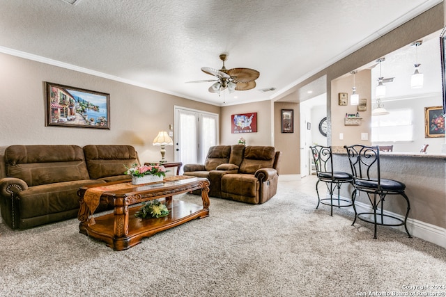 carpeted living room featuring crown molding, ceiling fan, and a textured ceiling