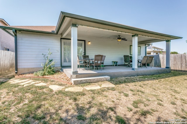 back of house featuring a patio, a lawn, and ceiling fan