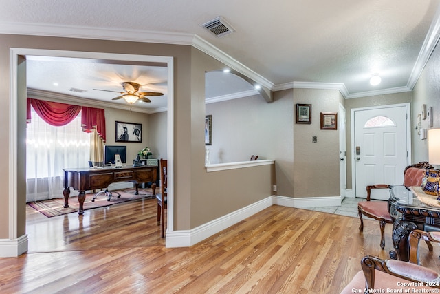 entrance foyer with ornamental molding, ceiling fan, a textured ceiling, and light hardwood / wood-style flooring