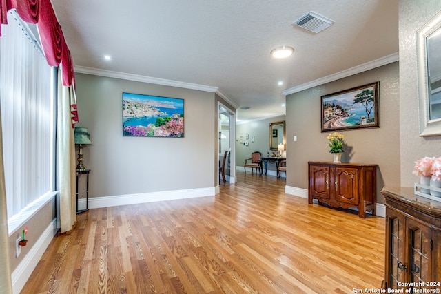 corridor with crown molding and light hardwood / wood-style floors