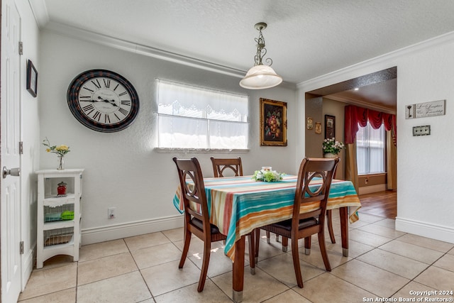 dining area featuring ornamental molding, light tile patterned floors, and a textured ceiling