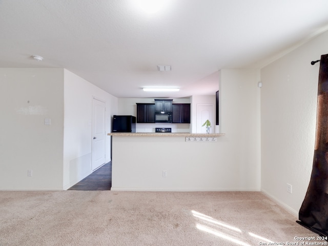 kitchen with dark colored carpet and black appliances