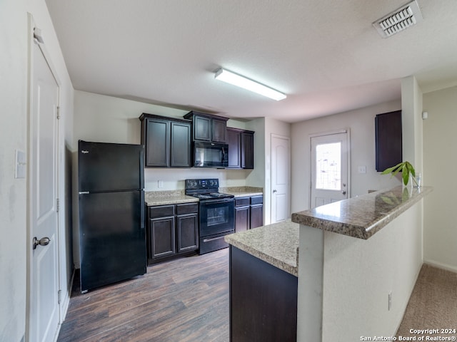 kitchen featuring black appliances, dark brown cabinetry, dark hardwood / wood-style flooring, kitchen peninsula, and a kitchen breakfast bar