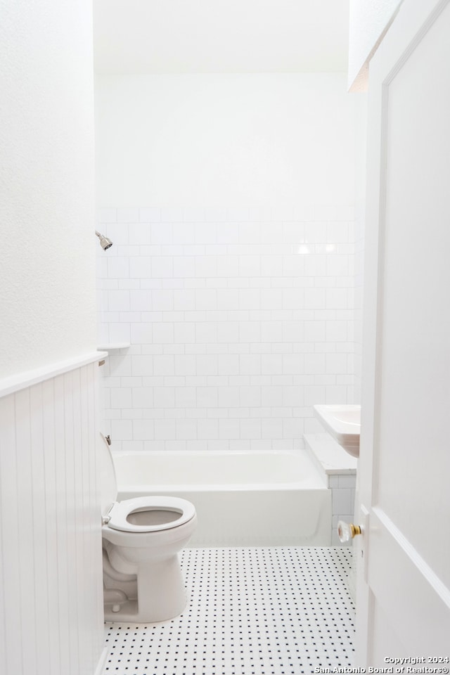 bathroom with tiled shower / bath and toilet