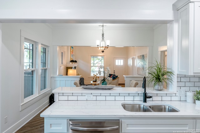 kitchen featuring dishwasher, hanging light fixtures, sink, and white cabinetry