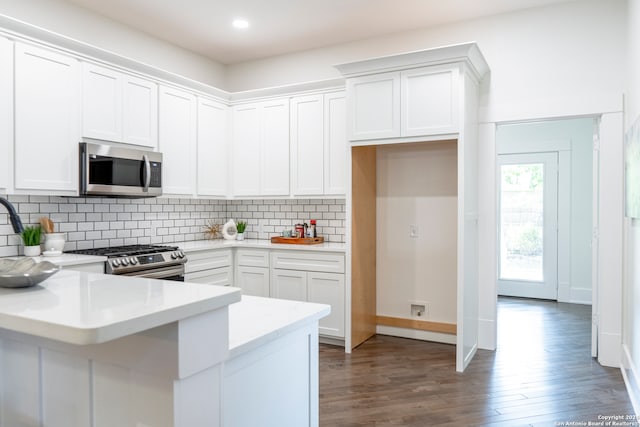 kitchen with tasteful backsplash, dark wood-type flooring, stainless steel appliances, and white cabinets