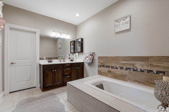 bathroom featuring tiled bath, tile patterned floors, and vanity