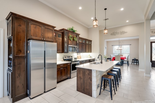 kitchen featuring dark brown cabinets, stainless steel appliances, hanging light fixtures, and sink