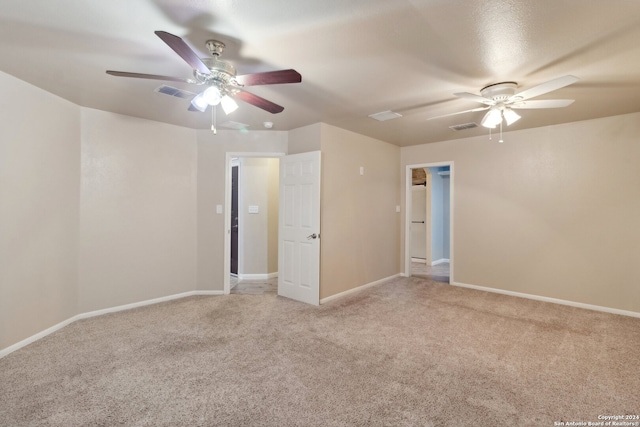 spare room with ceiling fan and light carpet