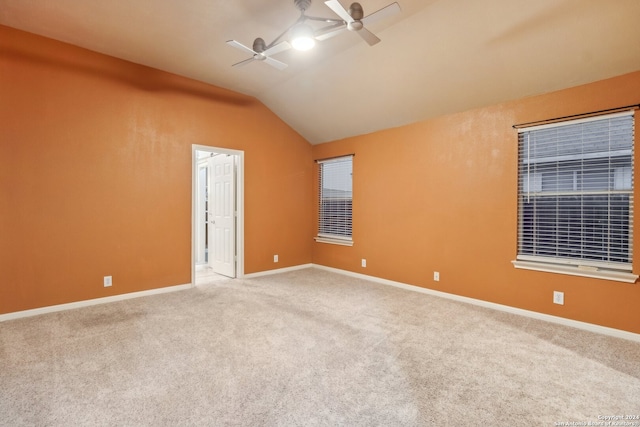 spare room with carpet floors, vaulted ceiling, and ceiling fan